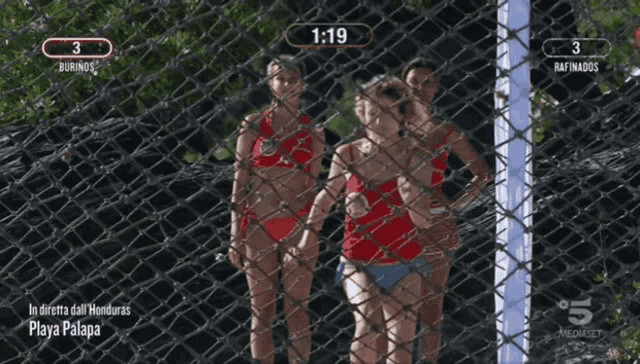 a woman in a red bikini is standing in front of a fence with 1:19 on the screen