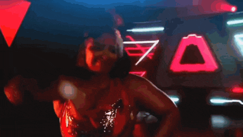 a woman in a red dress is dancing in front of a pink triangle