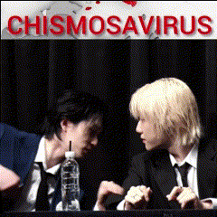 two men are sitting at a table with a sign that says chismosavirus