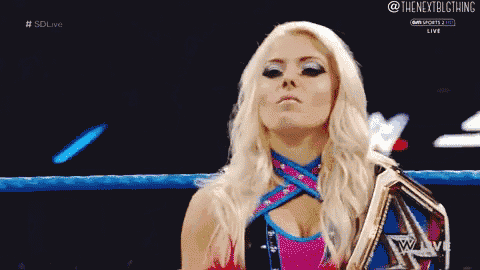 a woman is standing in a wrestling ring holding a championship belt