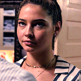 a woman is wearing a striped shirt and a necklace