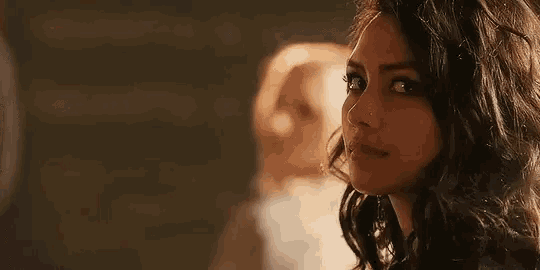 a close up of a woman 's face with a reflection of a person in the mirror .