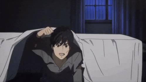 a man in a gray shirt is peeking out of a bed