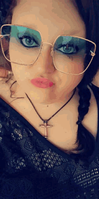 a woman wearing glasses and a necklace with a cross pendant