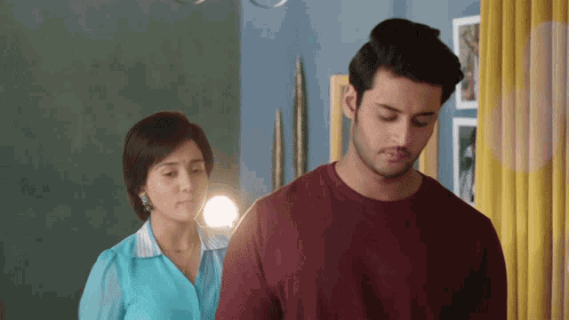 a man and a woman are standing next to each other in a room