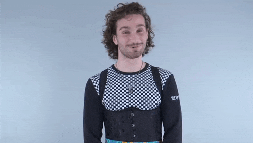 a man wearing a black and white checkered shirt is giving a middle finger