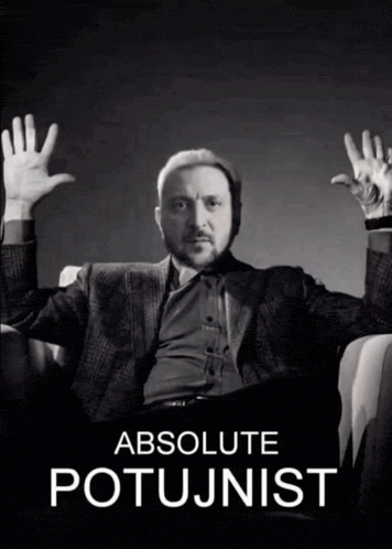 a man in a suit sits in a chair with his hands in the air and the words absolute potujnist behind him