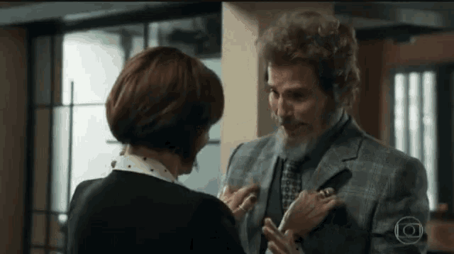 a man with a beard and a woman with short hair are standing next to each other