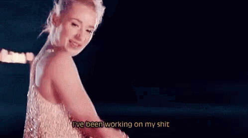 a woman in a white dress is dancing with the words i 've been working on my shit .