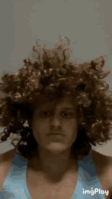 a woman with curly hair is being touched by someone 's hand and the words imgplay are on the bottom right