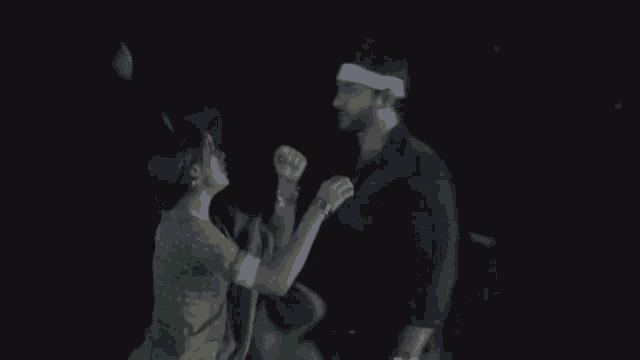 a man and a woman are dancing together in the dark .