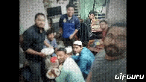 a group of people are gathered around a table eating food .
