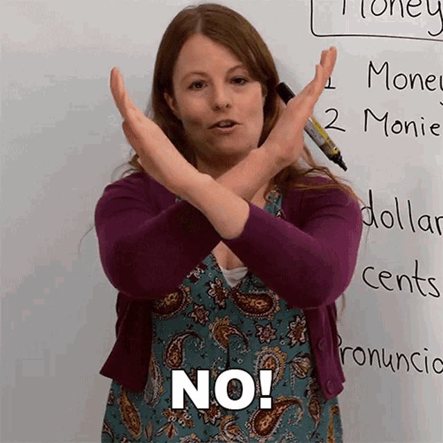 a woman crosses her arms in front of a white board that says money
