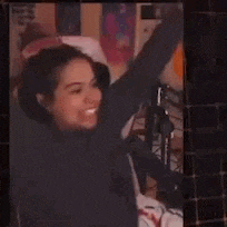 a woman is sitting in front of a microphone with her arms outstretched .