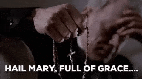 a man is holding a rosary in his hand and says `` hail mary , full of grace ... '' .