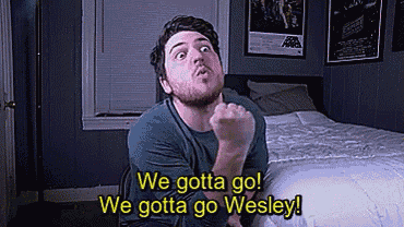 a man is sitting in front of a bed with the words we gotta go we gotta go wesley behind him