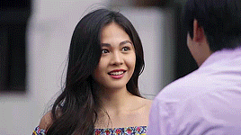 a woman is smiling while looking at a man .