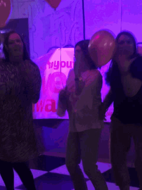 a group of people are dancing in front of a sign that says toy you