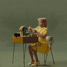 a woman in a yellow dress is sitting at a desk