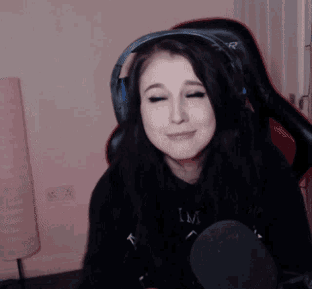 a woman wearing headphones and a black shirt with the letter m on the front