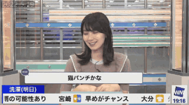 a woman is sitting in front of a screen that says 19:16