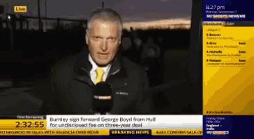 a man in a suit and tie is talking on a television screen