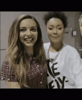 two women are standing next to each other and smiling .