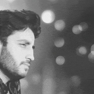 a close up of a man 's face with a beard in a black and white photo