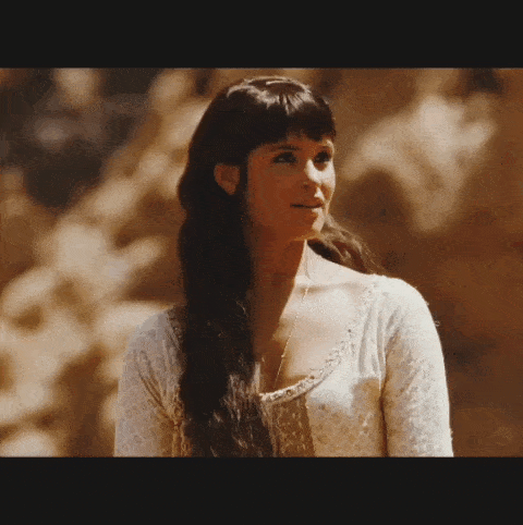 a woman with long dark hair wearing a white shirt