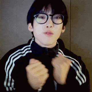 a young man wearing glasses and an adidas jacket