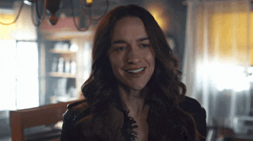 a woman with long hair is smiling in a room