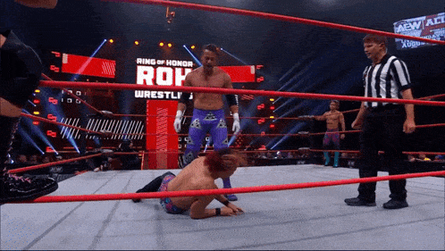 a wrestler is laying on the ground in a ring that says ring of honor on it