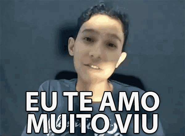 a young boy says eu te amo muito viu in front of a dark background