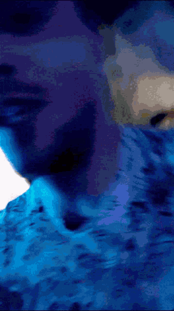 a blurry picture of a person laying on a bed with blue sheets
