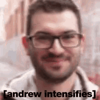 a man with glasses and a beard is smiling with the words andrew intensifies written below him .