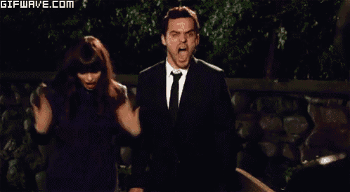 a man in a suit and tie is being punched by a woman in a black dress .