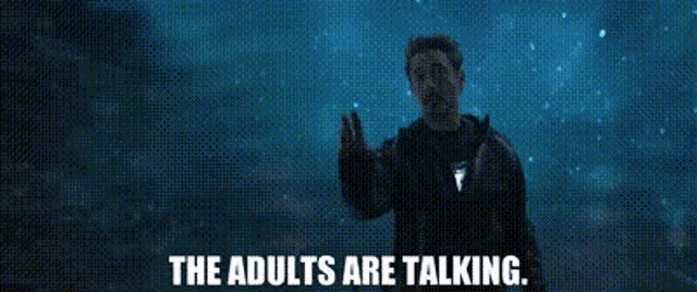 a man is standing in front of a starry sky with the words `` the adults are talking '' written below him .
