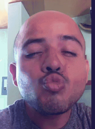 a close up of a man 's face with his eyes closed and his tongue out