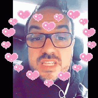 a man wearing glasses and headphones with pink hearts around his face