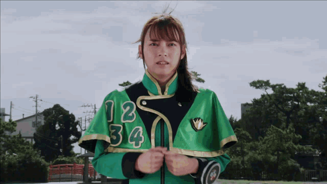 a girl in a green and black uniform with the numbers 12 34 on it