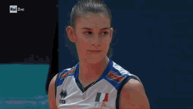 a female volleyball player wearing a white and blue jersey with the word italia on it