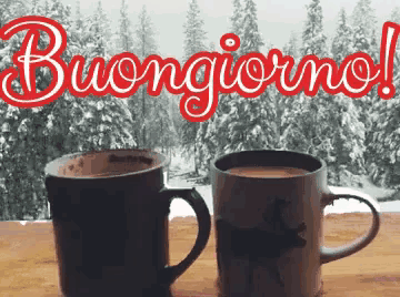 two cups of coffee are sitting on a table in front of a window with the words buongiorno written on it