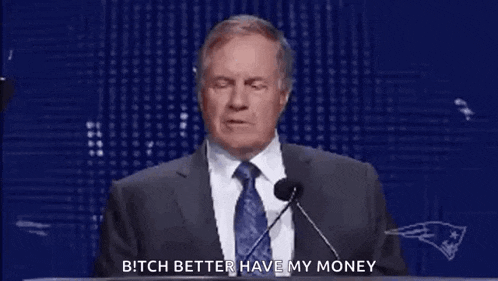 a man in a suit and tie is giving a speech while wearing rings on his hands .