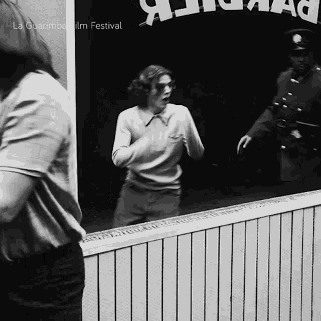 a man is standing in front of a sign that says la quanrmba film festival