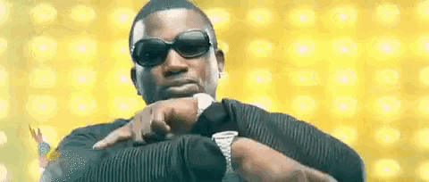 a man wearing sunglasses and a watch looks at his watch .