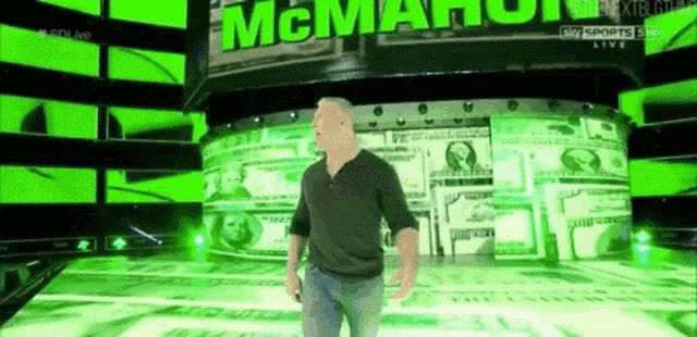 a man in a black shirt is standing in front of a wall of money and a sign that says mcmahon