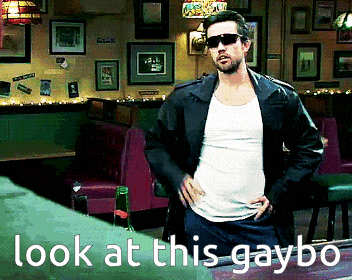 a man wearing sunglasses and a leather jacket stands in a diner with the words look at this gaybo written below him