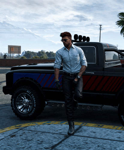 a man standing next to a truck that has a tire that says all terrain