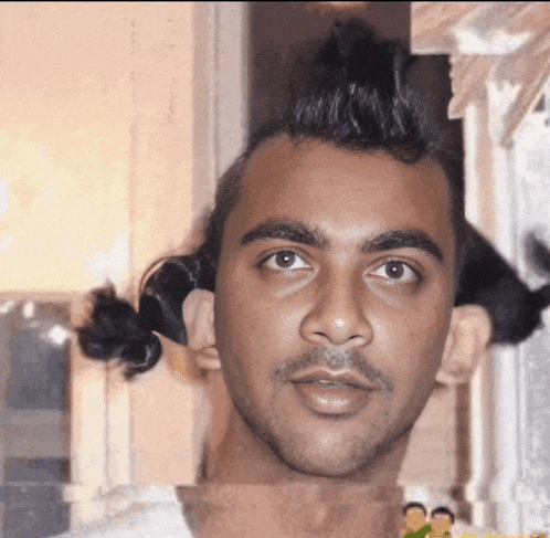 a close up of a man 's face with a ponytail
