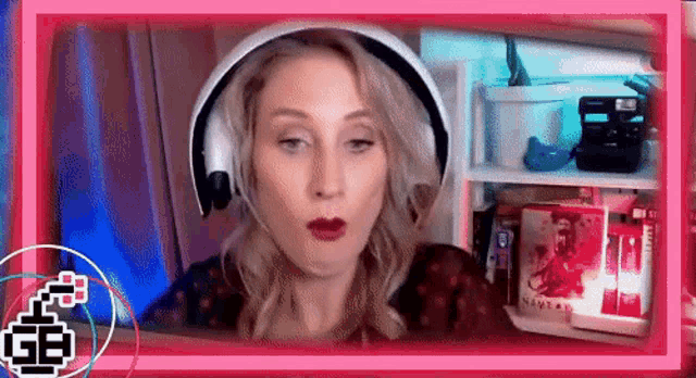 a woman wearing headphones is making a funny face while sitting in front of a computer screen .